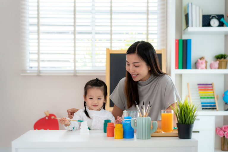 Home-Based ABA Therapy A Game Changer for Autism in Singapore Mother conducting a home-based ABA therapy session with her daughter, using colorful paints and art activities to support autism development in a Singapore home setting.