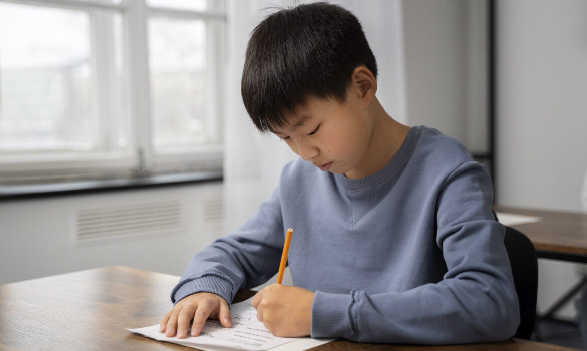 Focused young boy completing a written test at a desk in a classroom, representing the role of psychological assessments in unlocking children's cognitive and academic potential.