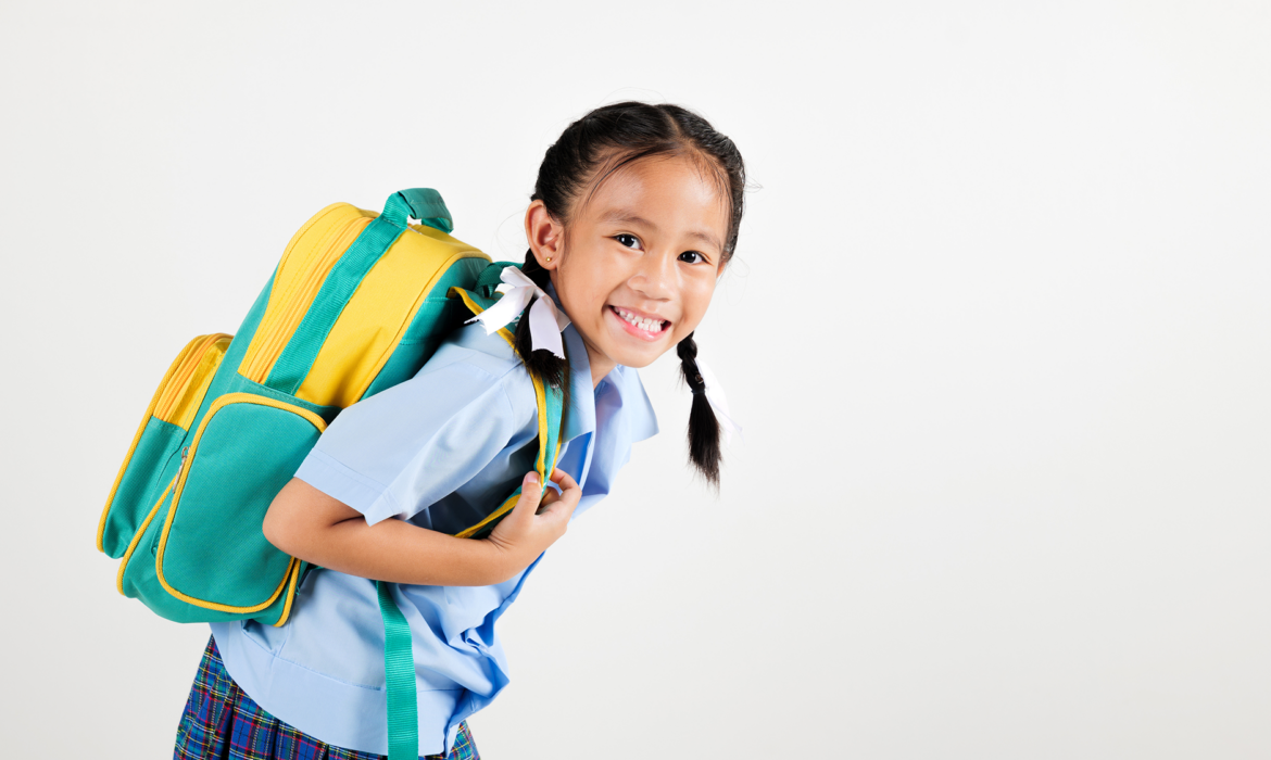 Smiling young schoolgirl wearing a backpack, symbolizing the importance of school shadowing programs for children with autism.