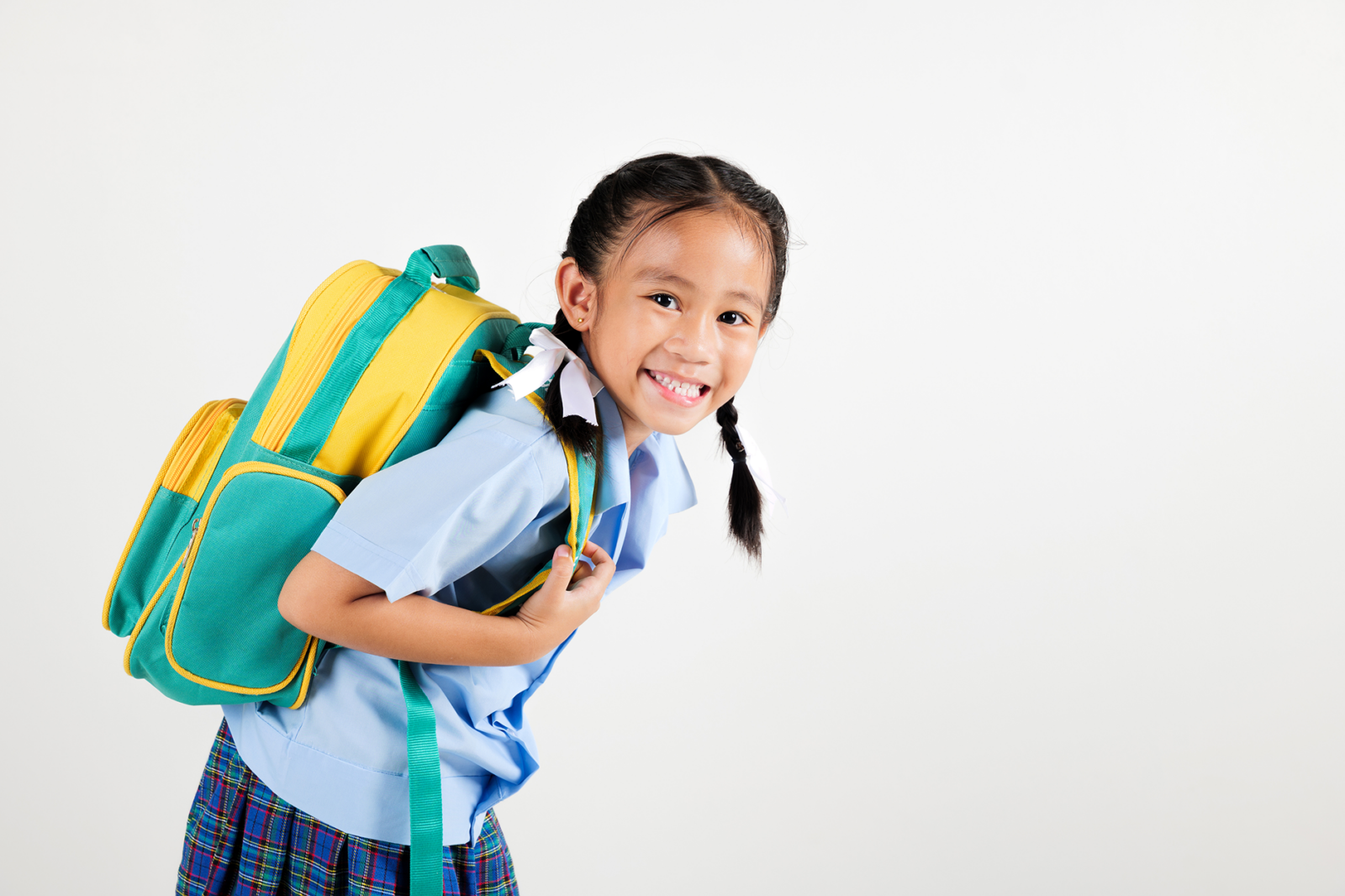 Smiling young schoolgirl wearing a backpack, symbolizing the importance of school shadowing programs for children with autism.