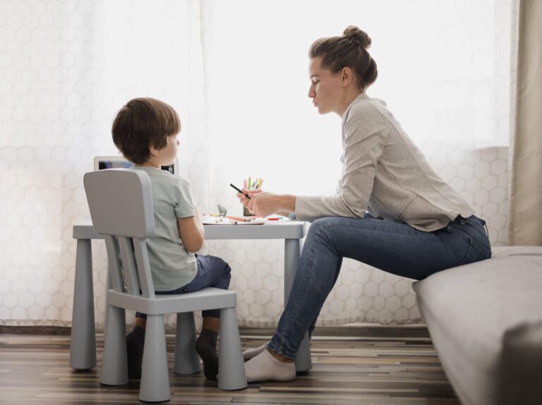 Autism Strengths and Weaknesses How to Nurture Potential Through Therapy Therapist working one-on-one with a young child at a small table, engaging in activities that support development, symbolizing how therapy can nurture strengths and address challenges in autism.