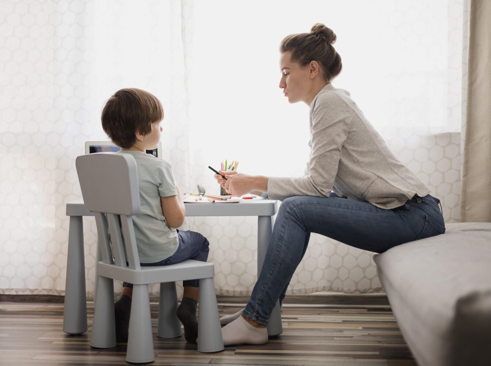 Therapist working one-on-one with a young child at a small table, engaging in activities that support development, symbolizing how therapy can nurture strengths and address challenges in autism.