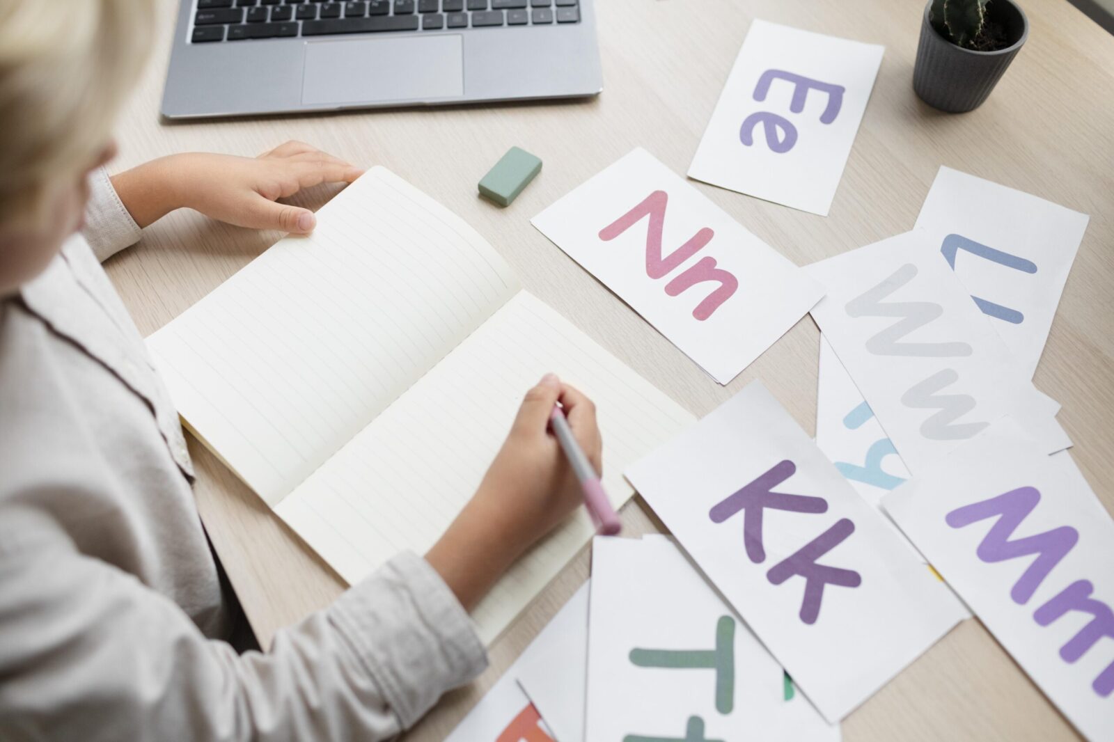Child practicing writing with alphabet flashcards during a speech therapy session, highlighting benefits of speech therapy for children.