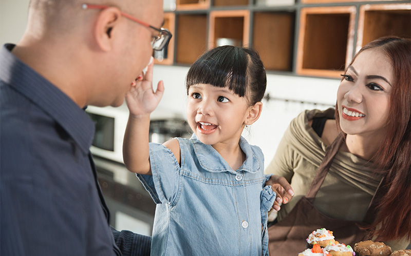 A happy family bonding together and eating cake