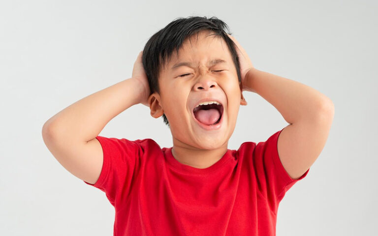 Child experiencing sensory overload and autism meltdown.