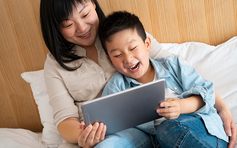 Mother and son managing screen time together on tablet.