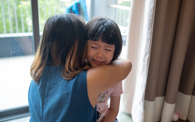 Woman comforting a child during an emotional autism meltdown.