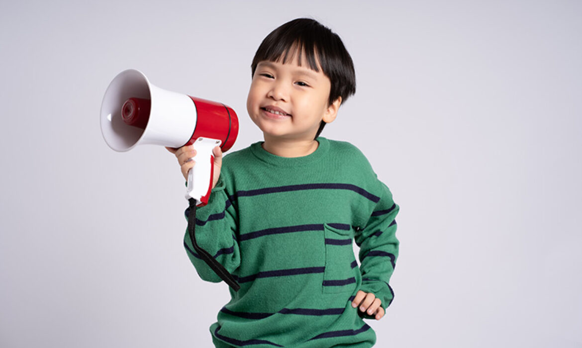 A young child holding a megaphone, representing speech and communication efforts.