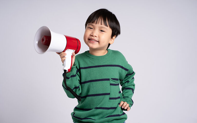 A young child holding a megaphone, representing speech and communication efforts.