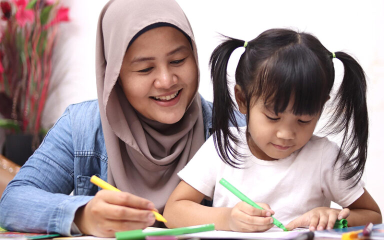 Educator using coloring activities for an autism behavior checklist.