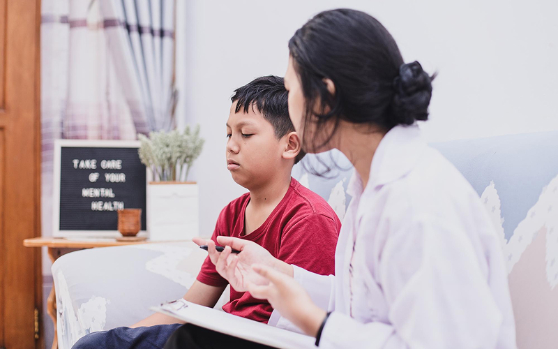 Specialist consulting with a boy about his mental health.